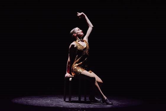 Contempory dancer performing using a stool in the routine